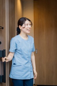 サロンの入口で笑顔で出迎えるセラピスト